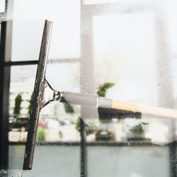 close-up view of cleaning and wiping window with squeegee
